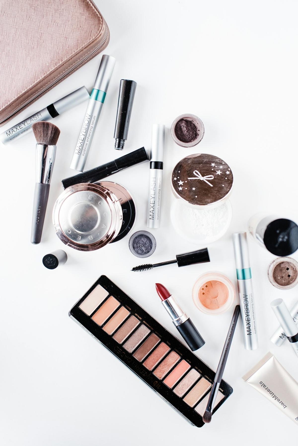 Makeup products and brushes laid out on a white surface