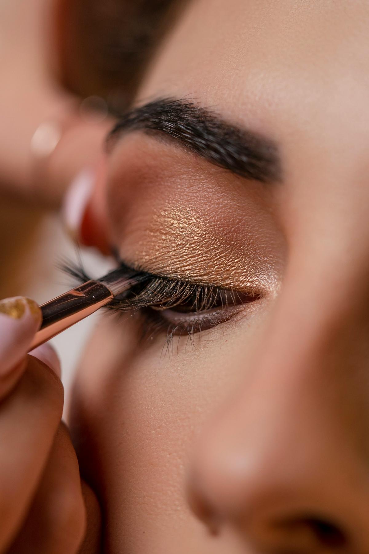 Close-up of shimmering eye makeup being applied with a brush