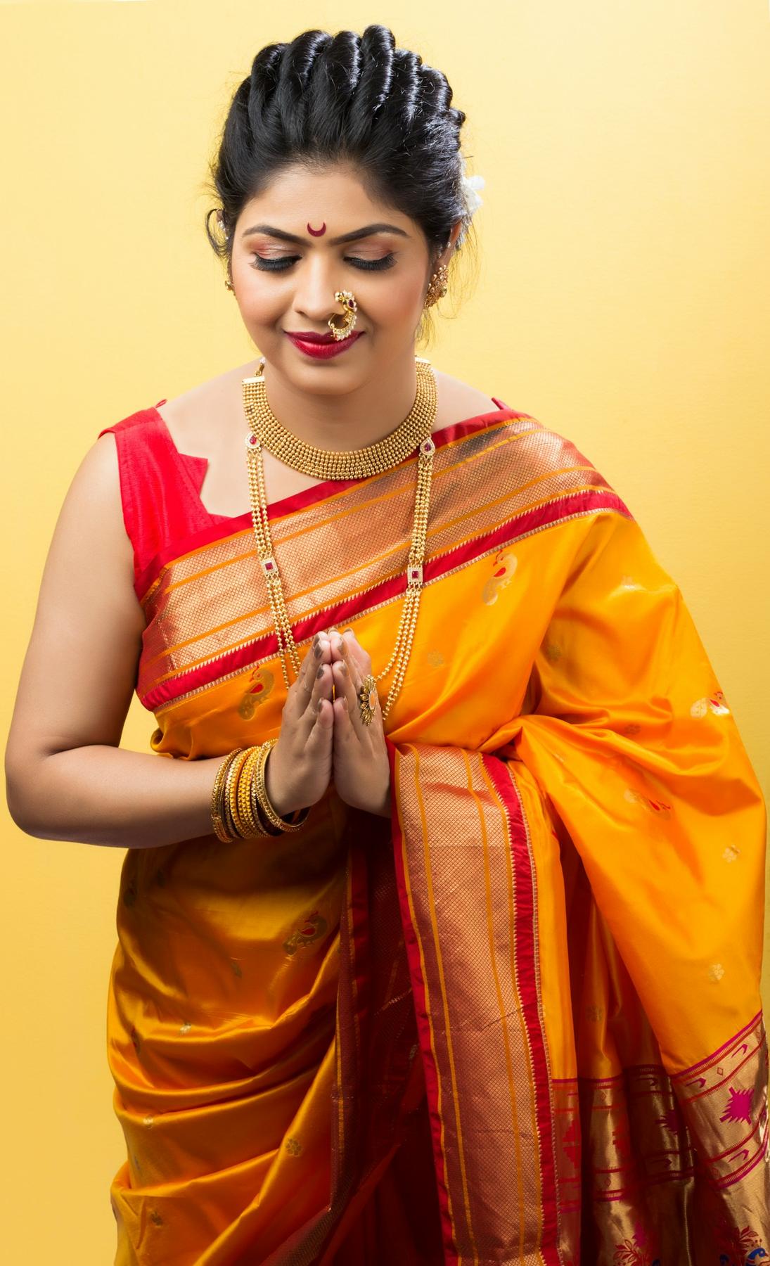 Woman in a yellow silk saree with festive makeup and jewellery